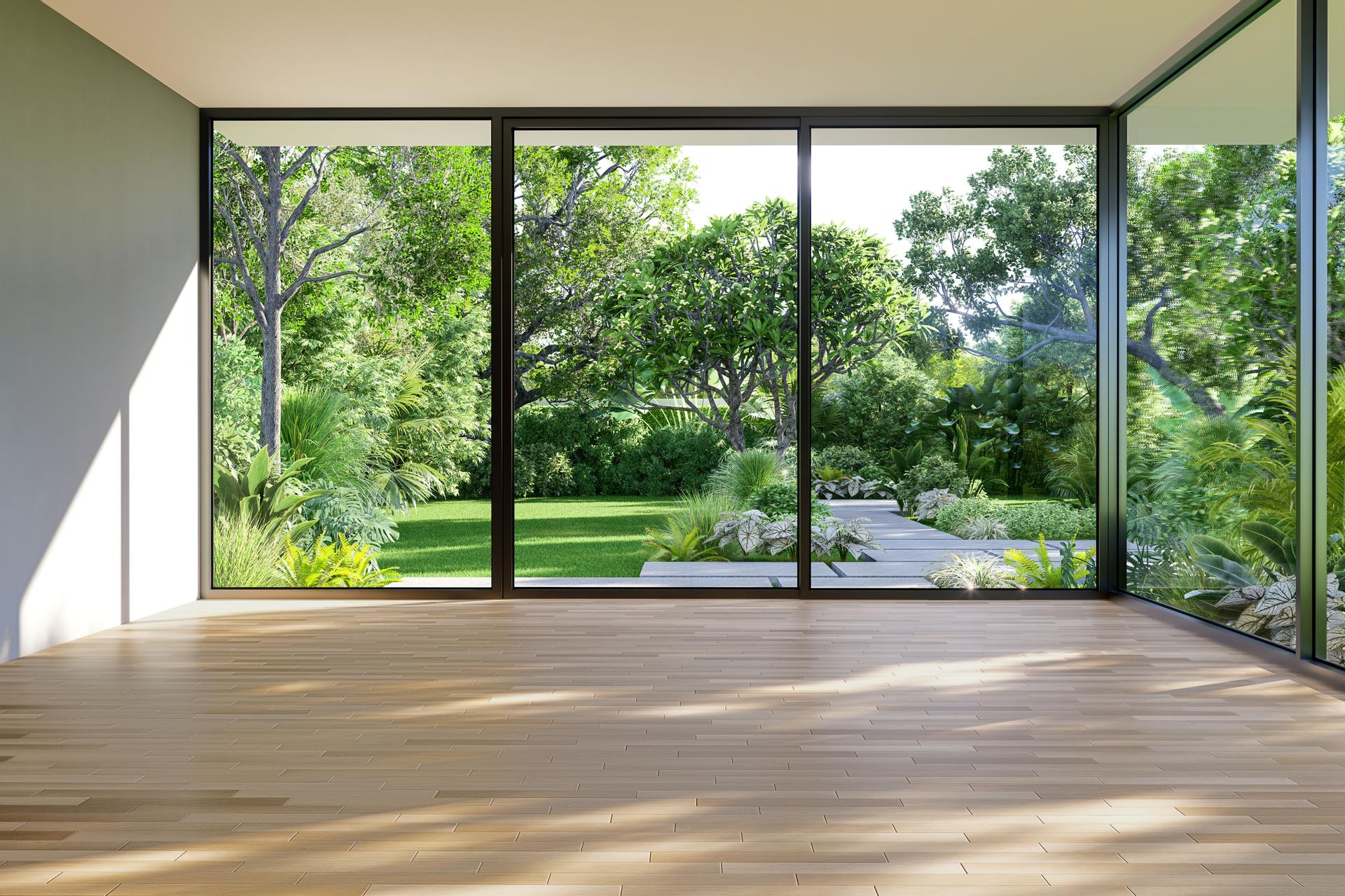 Modern empty room with large crystal clear windows showing beautiful view of yard.
